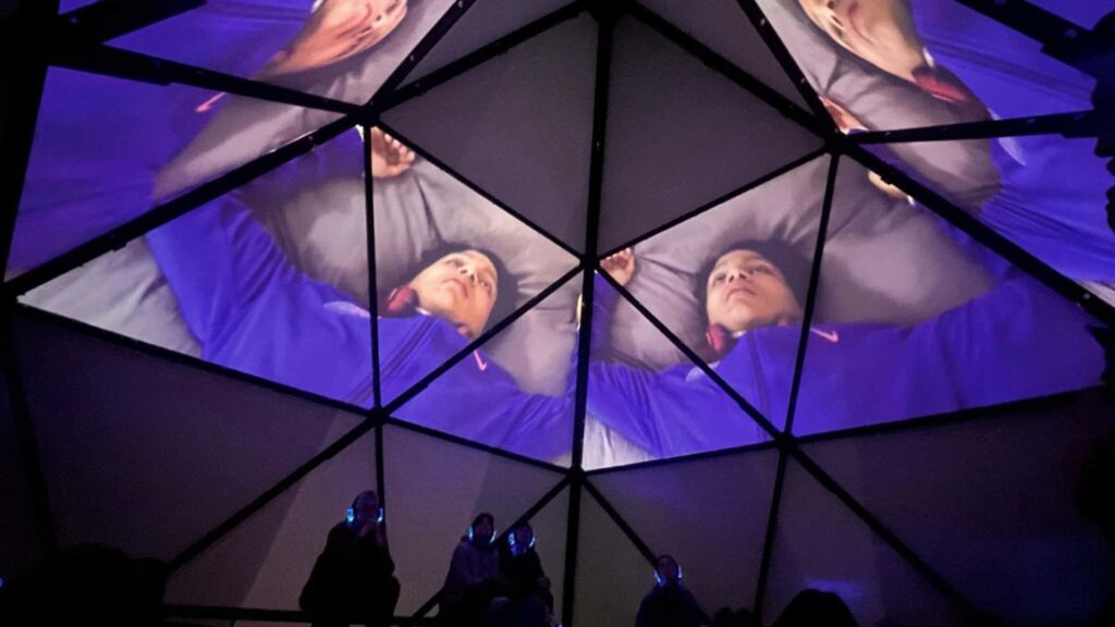 Inside a bespoke pyramid tent with 3d projection on the ceiling.