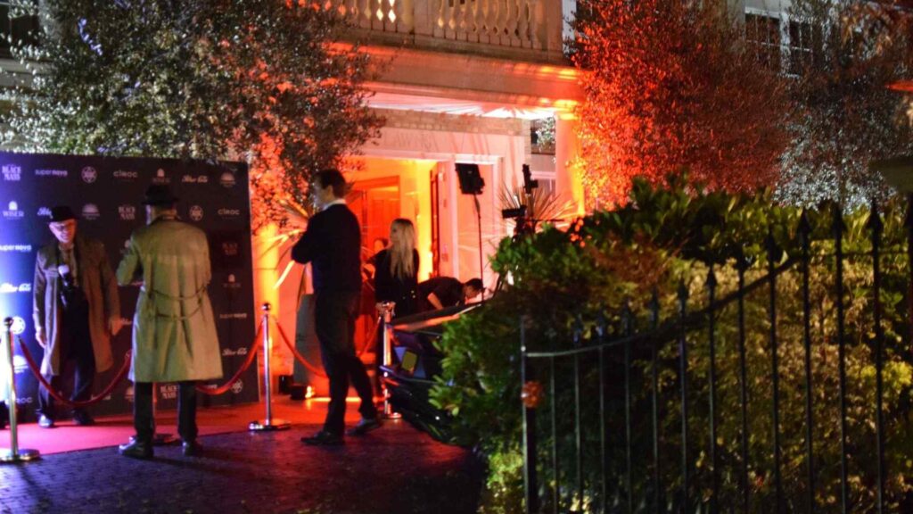 Cult Awakening Halloween mansion party front entrance and driveway with themed performers and red-carpet photo area.