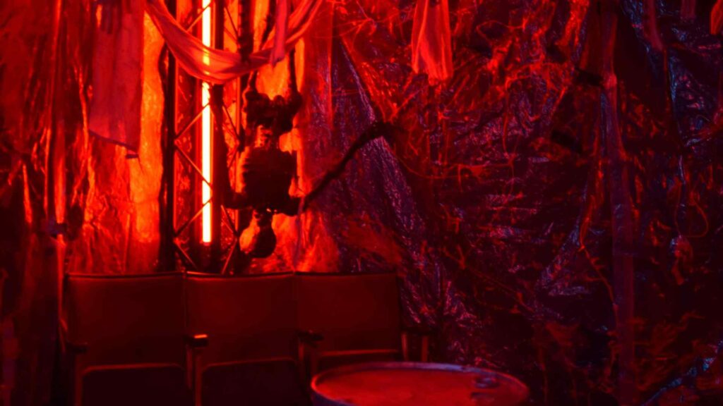 Halloween themed draping complete with hanging skeleton prop and red neon lighting.