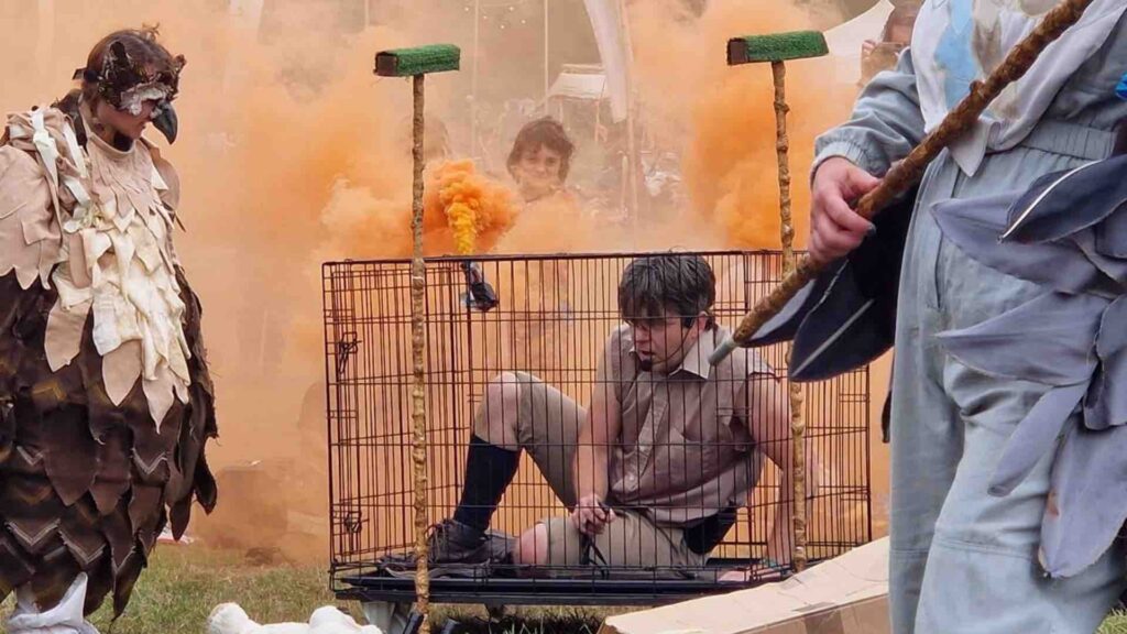 A handler locked in a cage by his mischievous birds