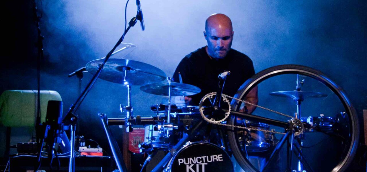 Experience the fusion of art and music as a passionate performer takes center stage, playing an extraordinary drum kit ingeniously built from a bicycle.