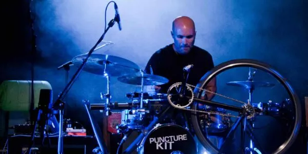 Experience the fusion of art and music as a passionate performer takes center stage, playing an extraordinary drum kit ingeniously built from a bicycle.