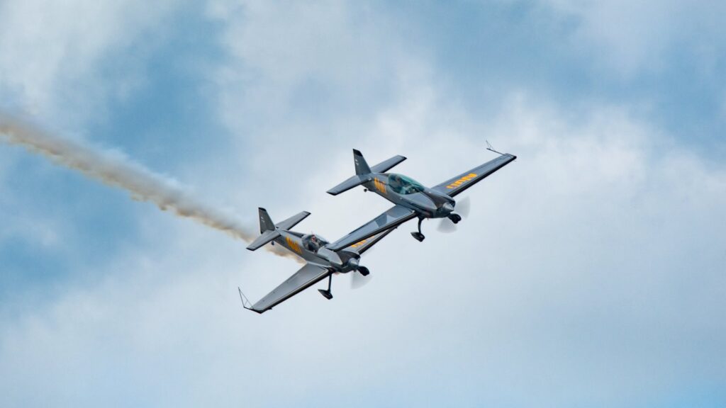 Duo of air planes performing at an aerial display.