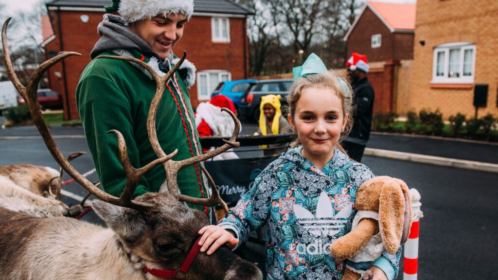 Simple Life community christmas event with reindeer and child.