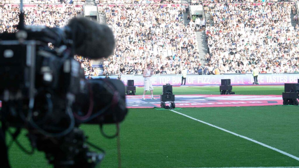 Camera filming Aitch's LIVE performance on the pitch, from pitch side. Several cameras were set up to move to different angles and shots throughout the performance for a high quality live production.