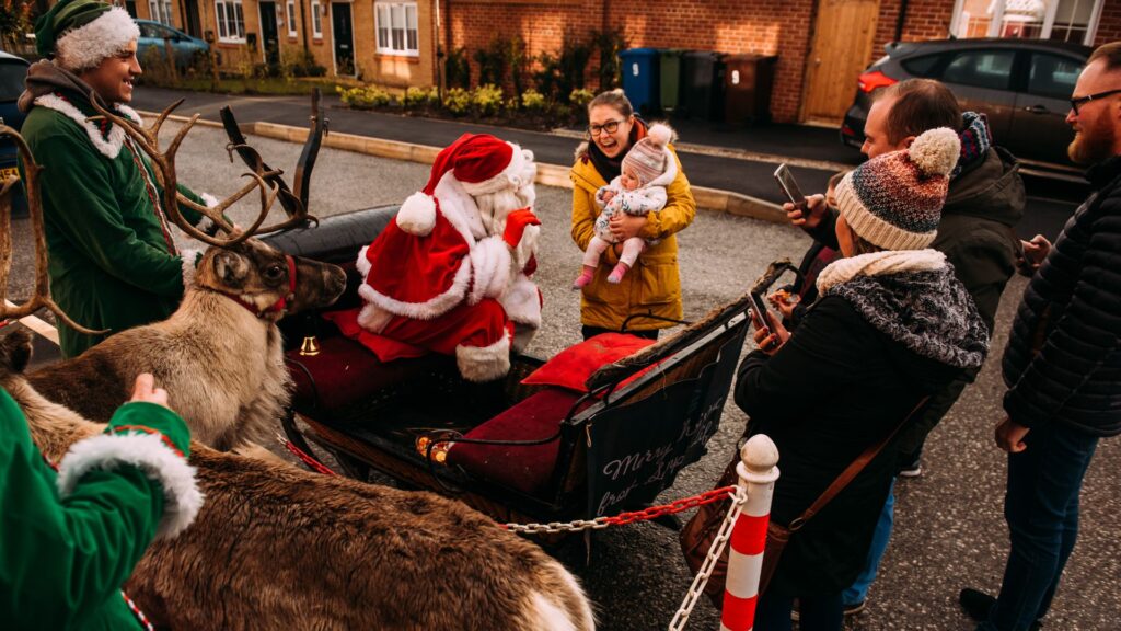 A santas sleigh at a Simple Life community event with santa meeting guests.