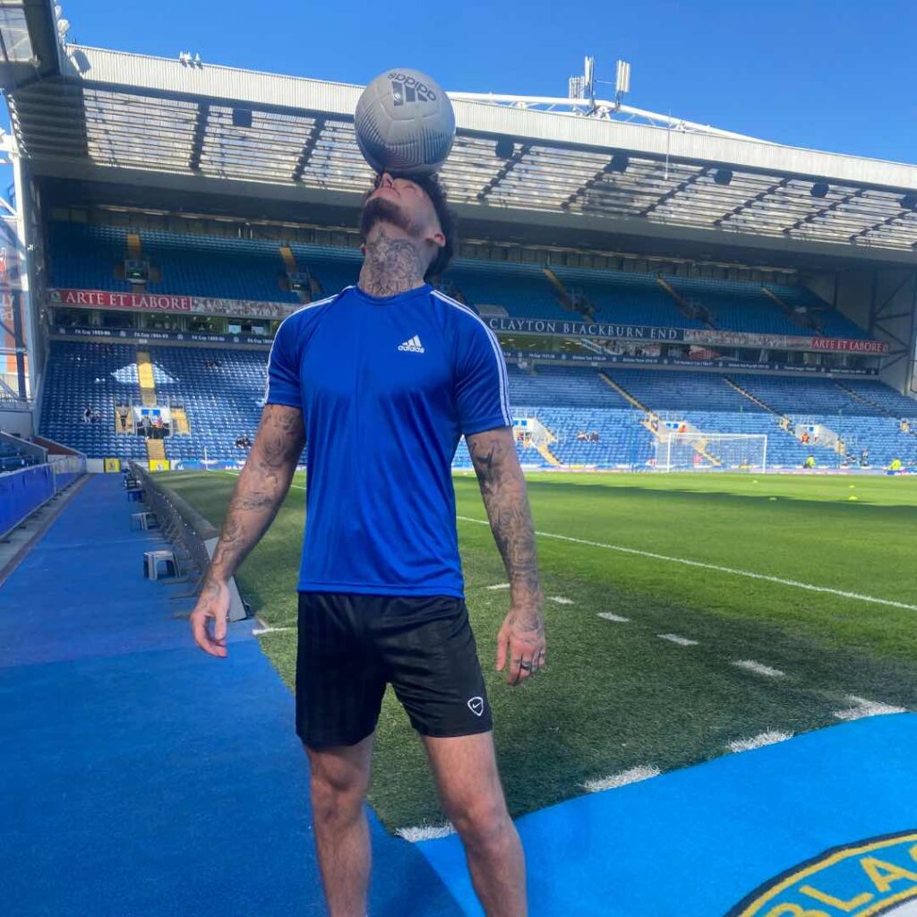 A football trickster performing a head balancing act.