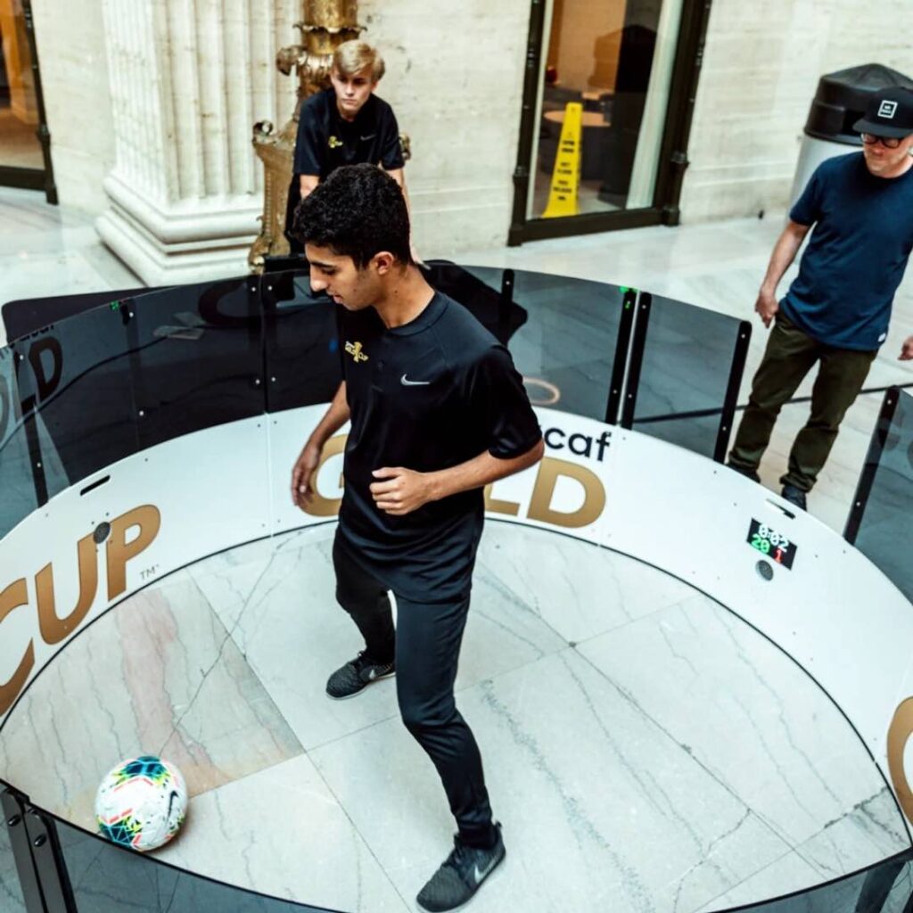 A guest testing his skill on a fast feet football activation.