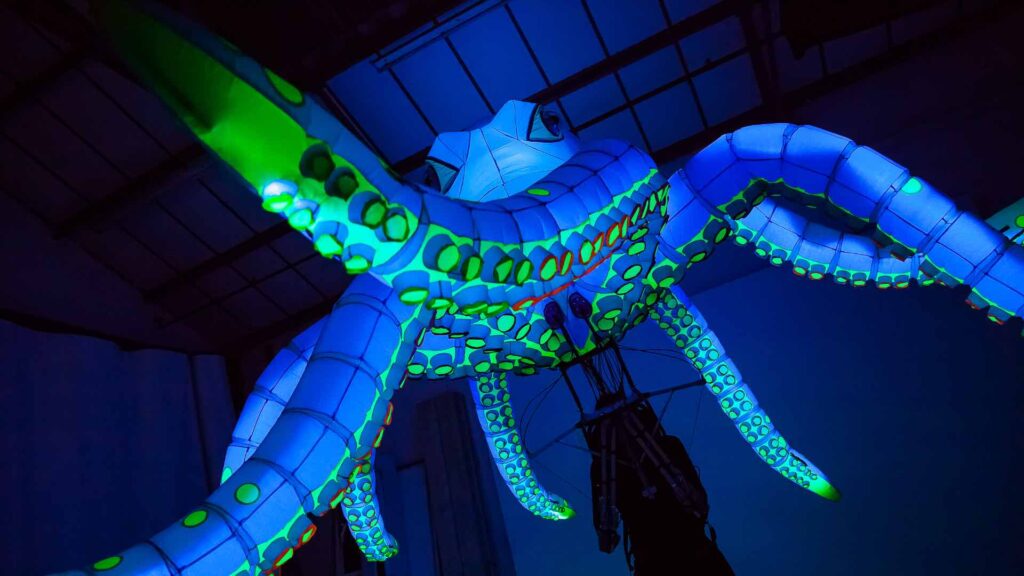 A giant LED octopus puppet with blue skin and tentacles for events.