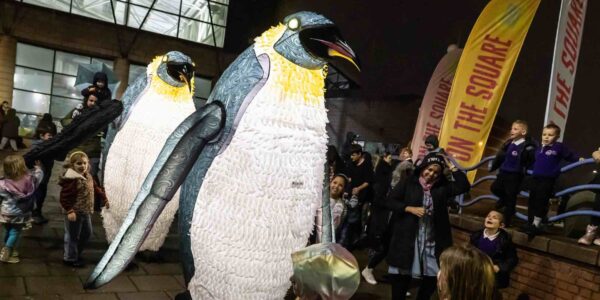 Light up penguin puppets performing for crowds at this Christmas public event.