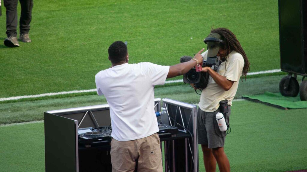 DJ Win, Aitch's DJ, being filmed by cameraman for livestream.