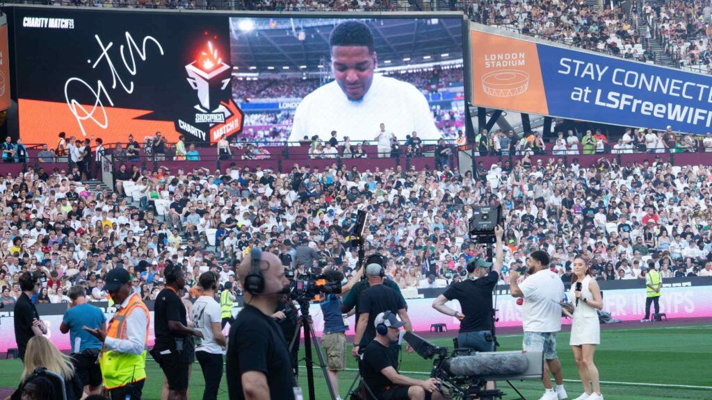 DJ Win on stadium screen during Aitch halftime performance.