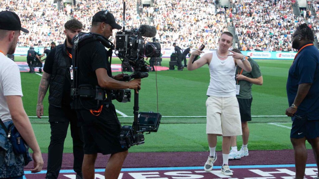 Aitch leaving the pitch after halftime performance.
