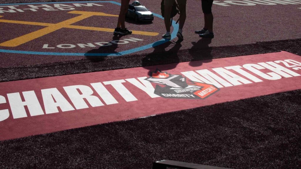 Sidemen Charity Match 2023 banner on pitch side floor, below West Ham crest.