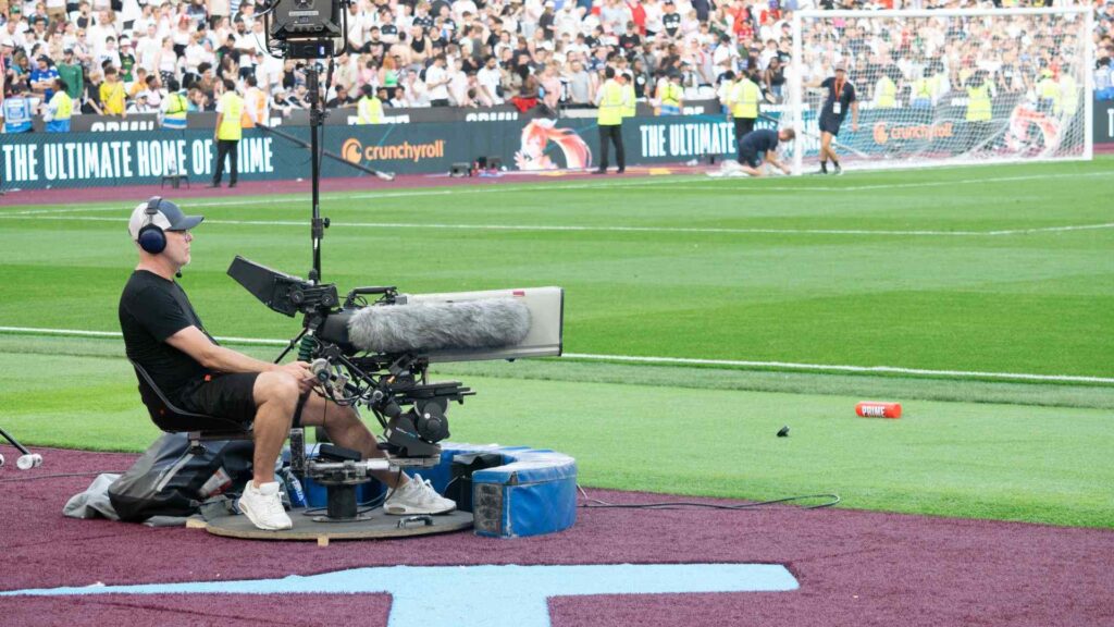 Camera man operating static swivel camera pitch side.