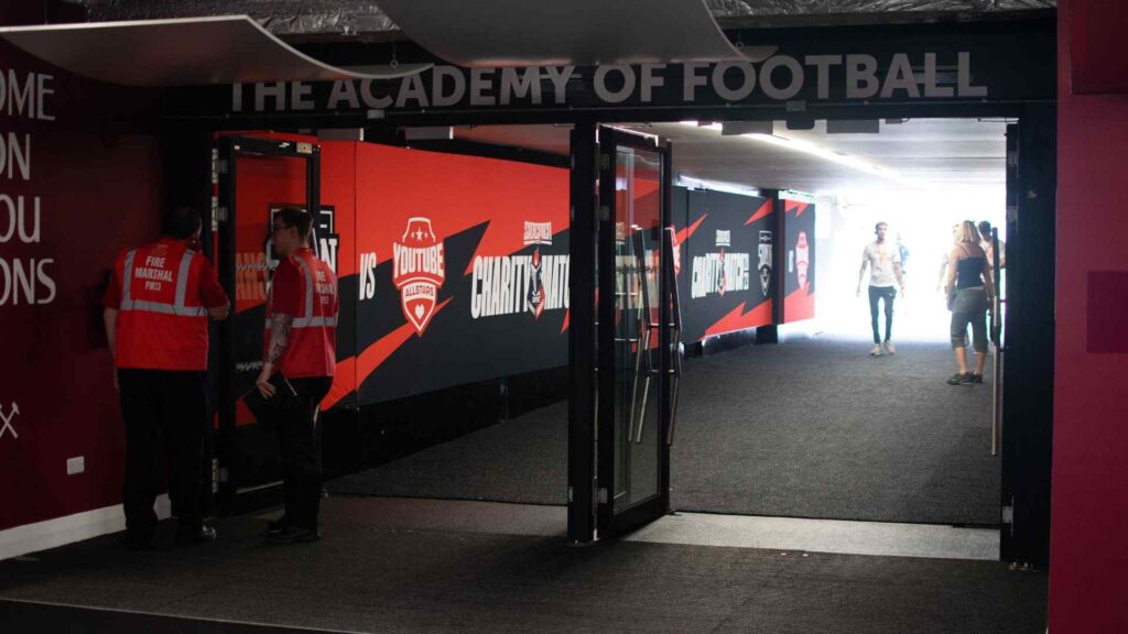 Player tunnel with Sidemen Charity Match branding and staff setting up inside.