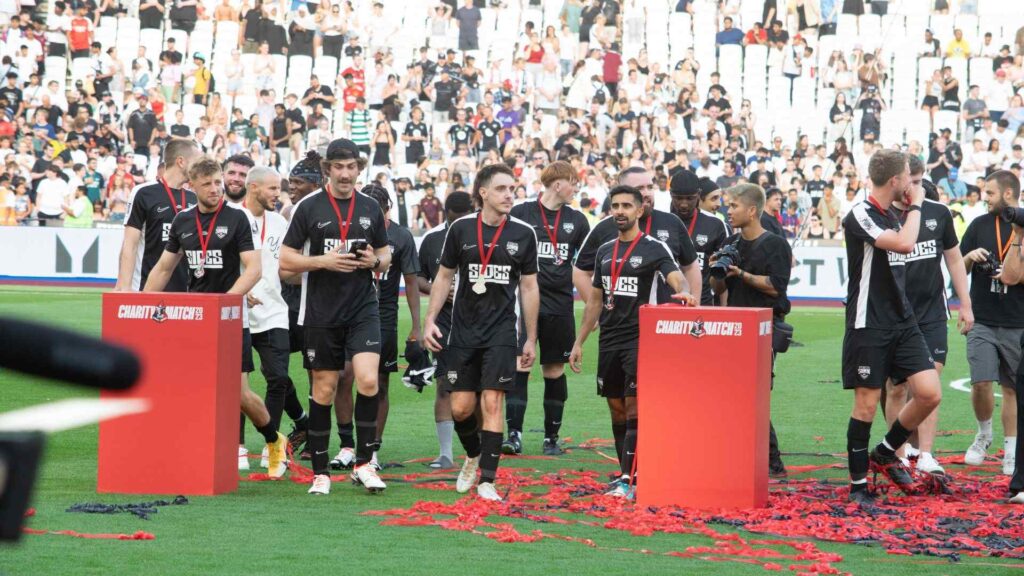 Sidemen FC walking around pitch celebrating the win with fans.