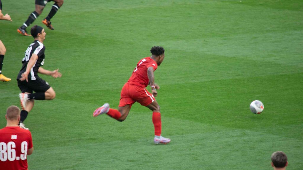 Speed sprinting past Tareq on the ball.