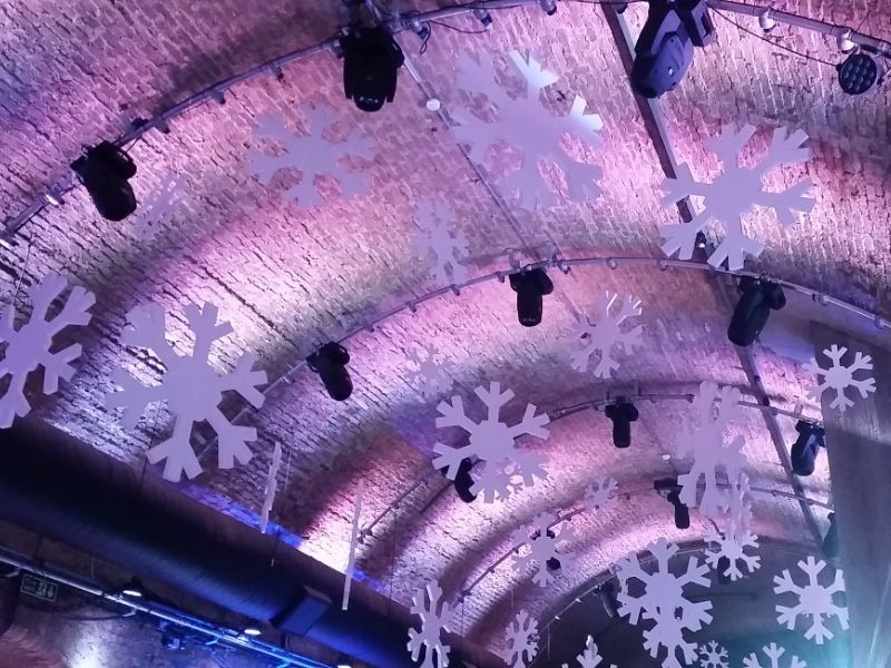 Hanging snowflakes from ceiling of event space. 