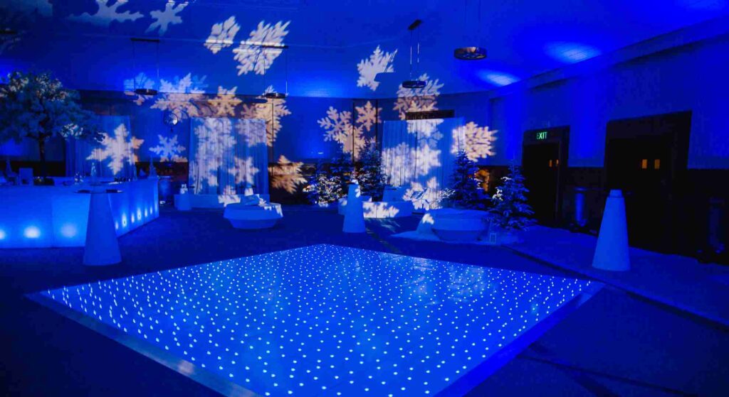Winter Wonderland snowflake 3d projection and sparkling dance floor at Christmas party event. 