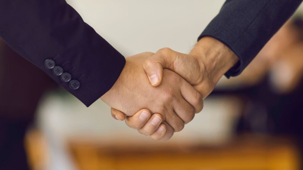 Two people shaking hands; illustrating customer engagement with brand.