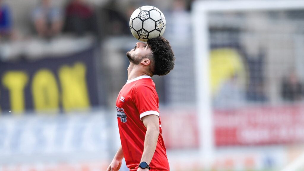 Football trickster performing ball balancing routine.