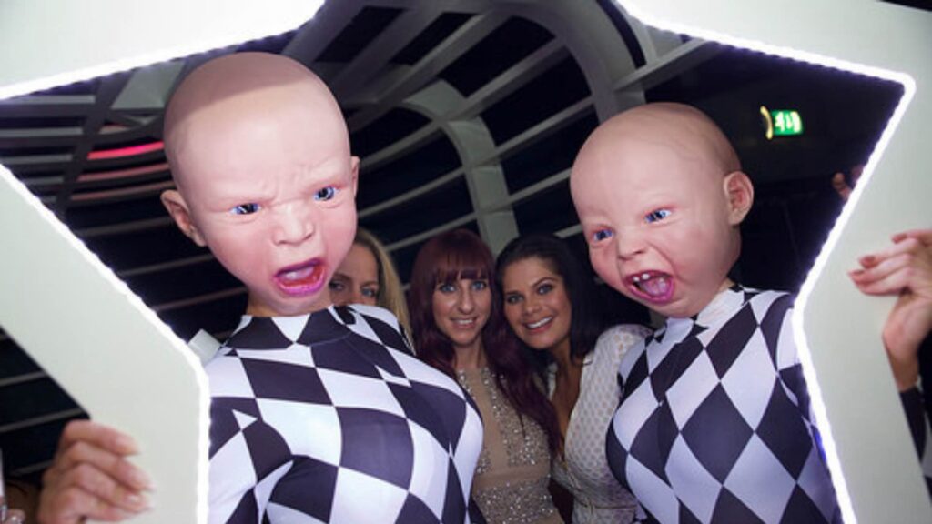 Creepy baby heads posing with guests at an event.