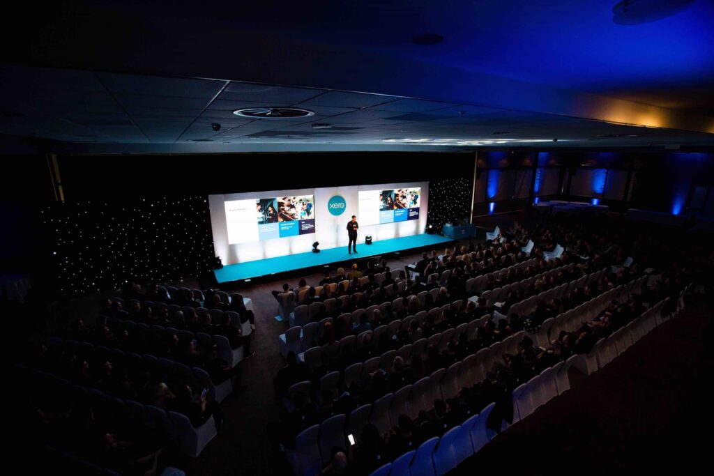 Sustainable conference event; view of guest speaker on stage.