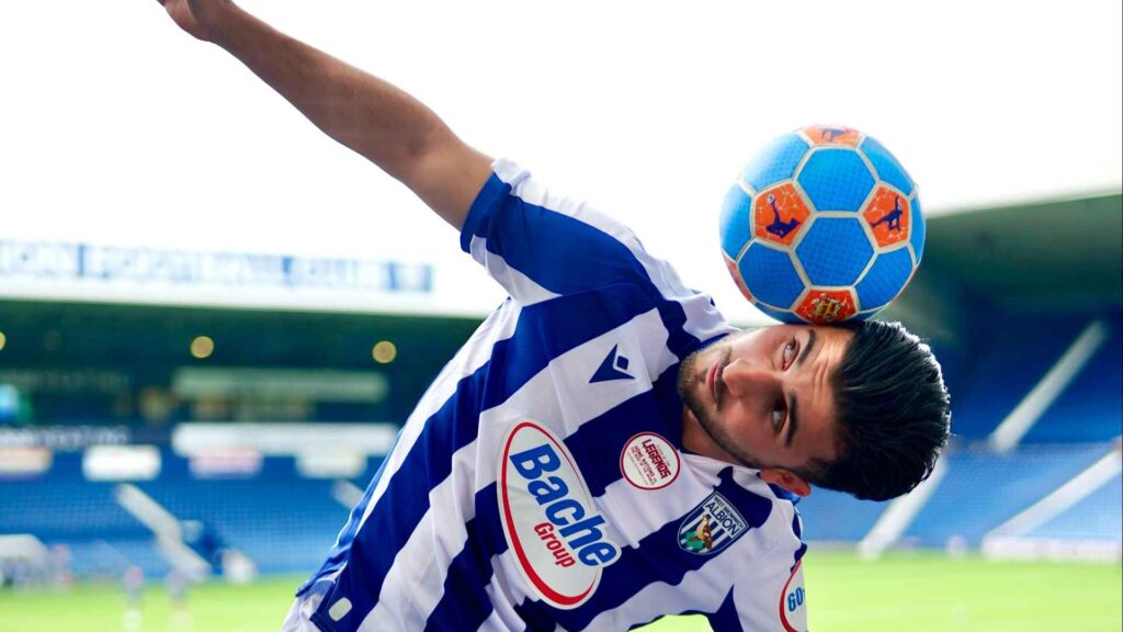 Our football freestyler at a football stadium doing tricks.