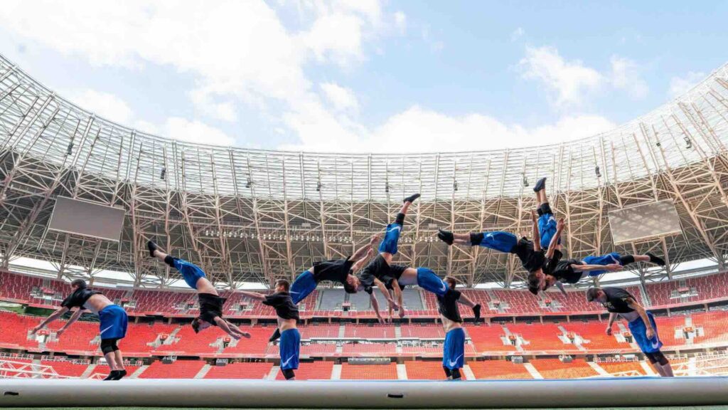 Acrobatic tumbler does flips on air track.