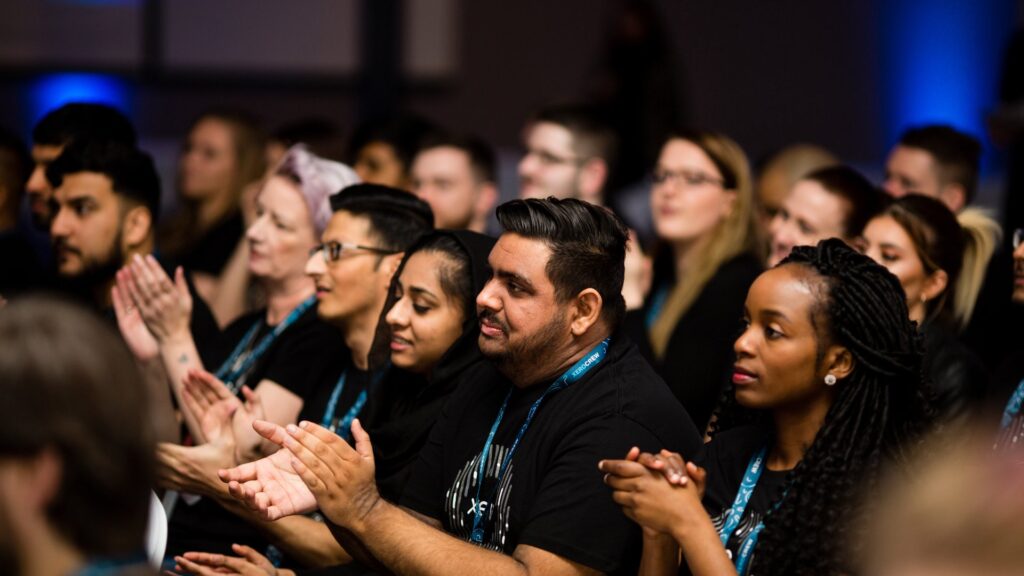 Xero employees clapping a conference presentation.