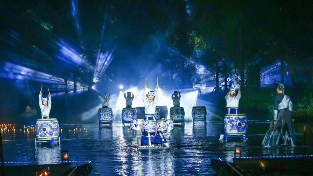Chinese drummers performing over water.