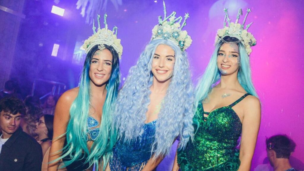 Three walkabout mermaids at nightclub event.