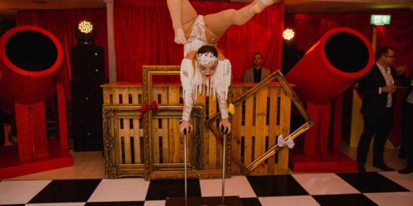Incredible acrobat performing stunts alongside circus event theming.