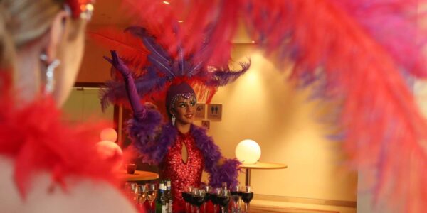 Stunning showgirl serving crowds with drink at a casino las vegas theme event.