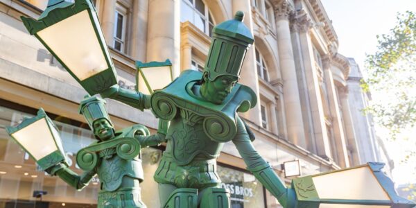 Lamp-Post-Stilt-Walkers-On-Busy-High-Street