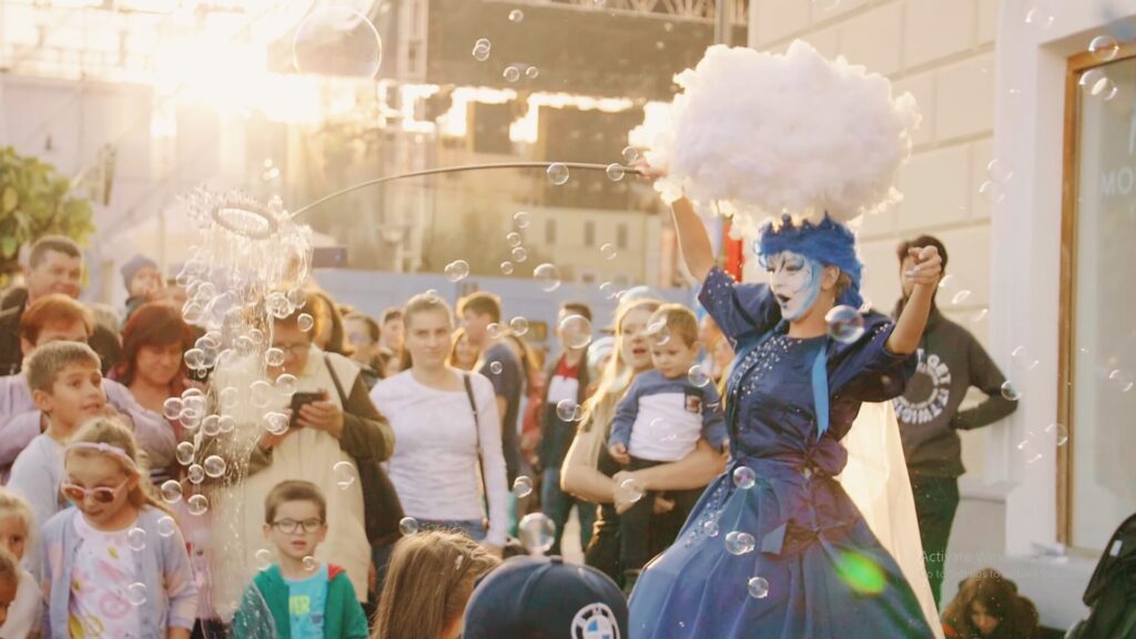 Cloud performer entertaining a crowd of children with bubbles