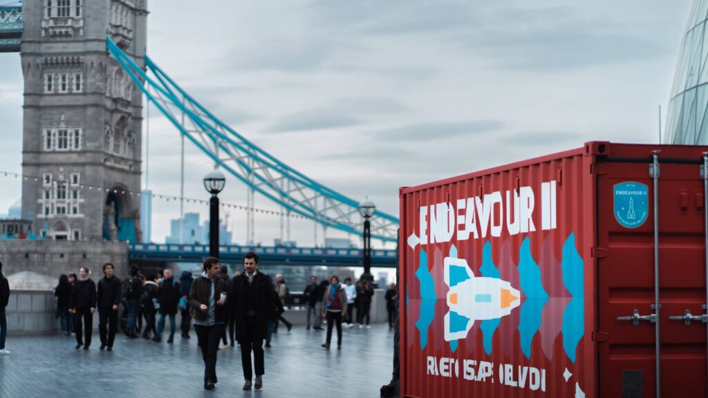 Shipping container escape room endeavour 2 sitting by bridge in London.