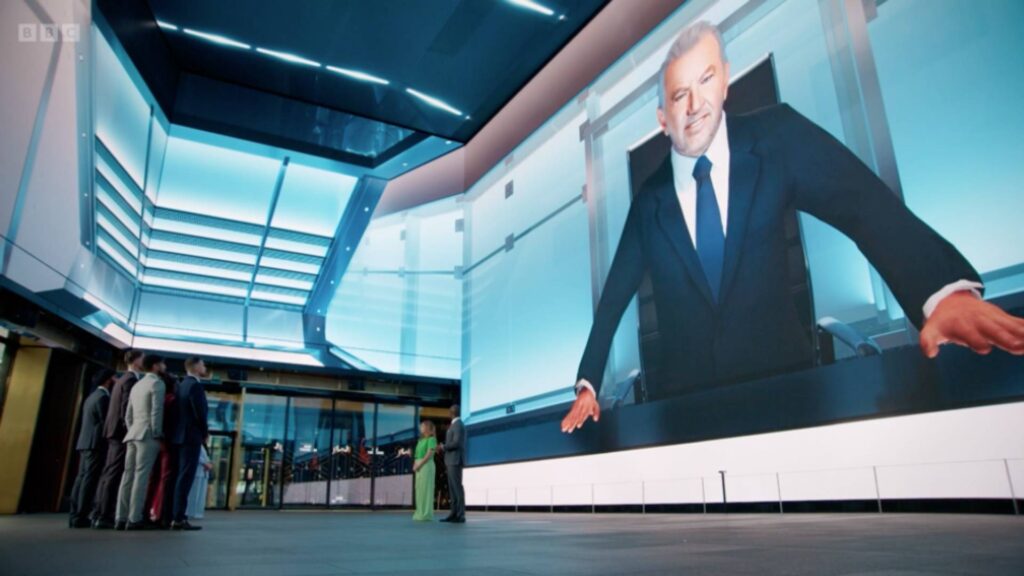 BBC The Apprentice screenshot from Iplayer of lord alan sugar as a virtual character introducing virtual escape room challenge in London.