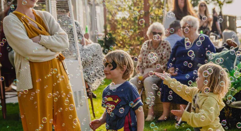 Children playing with bubbles at a family fun day event.