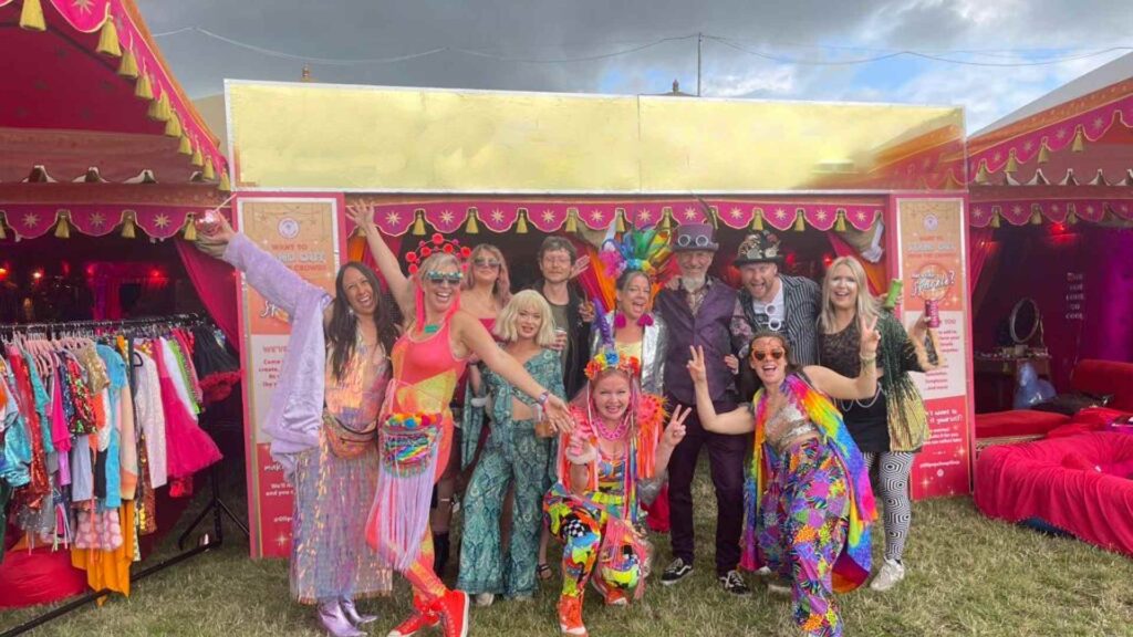Guests wearing fancy dress swap shop outfits at festival.