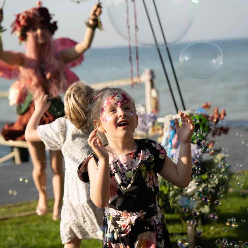 Girl playing with bubbles at an immersive family fun day event.