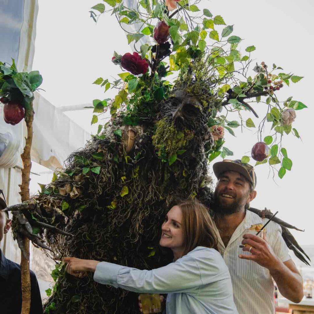 Tree Stilt Walker walkabout entertainment and posing hugging guests.