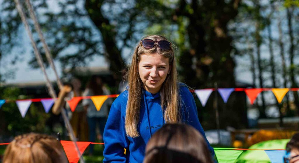 Family Fun Day activity leader talking to children about what to do.