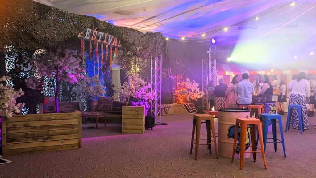 Indoor festival theme including signage and pallet furniture with guests enjoying this corporate festival.