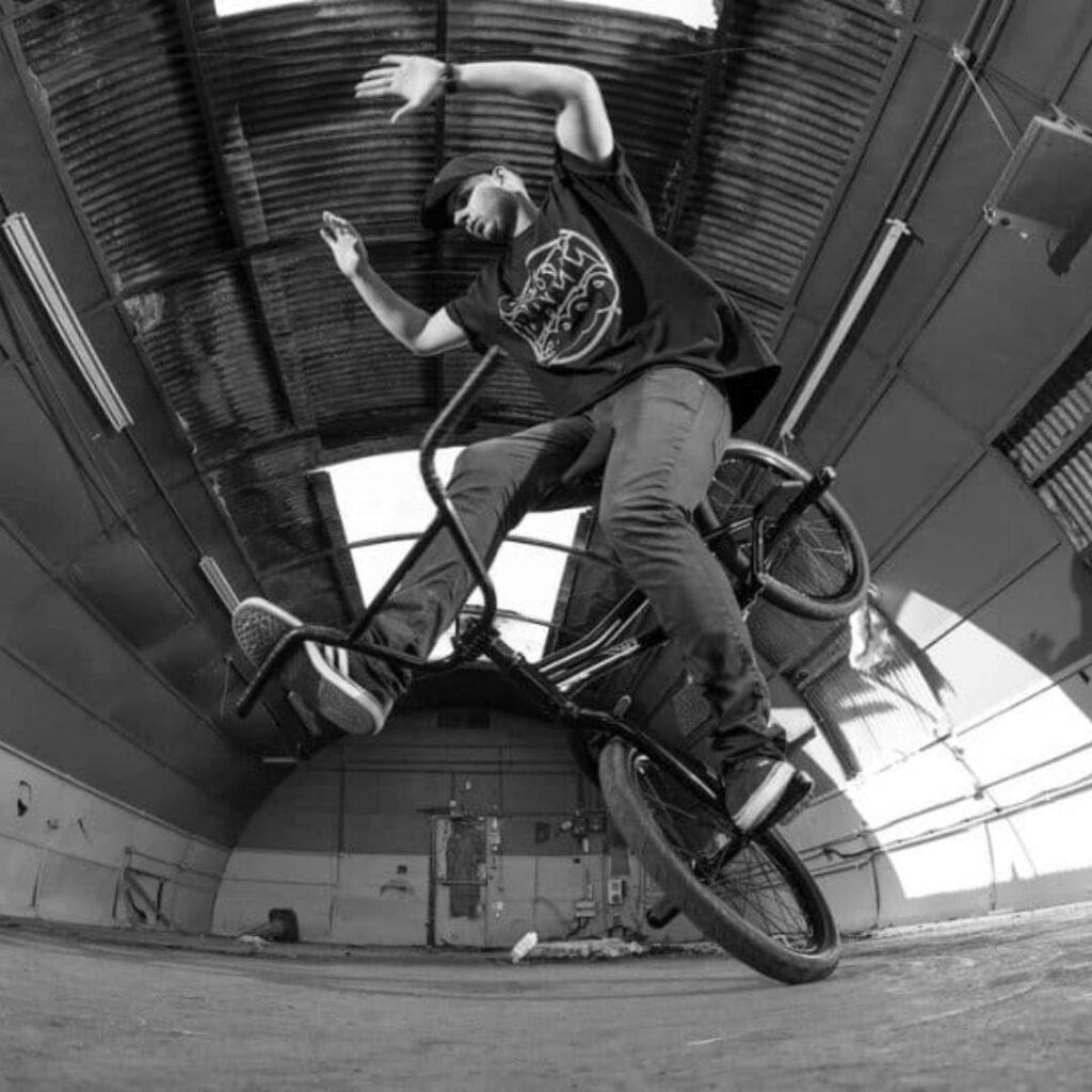BMX freestyler performing biking trick.