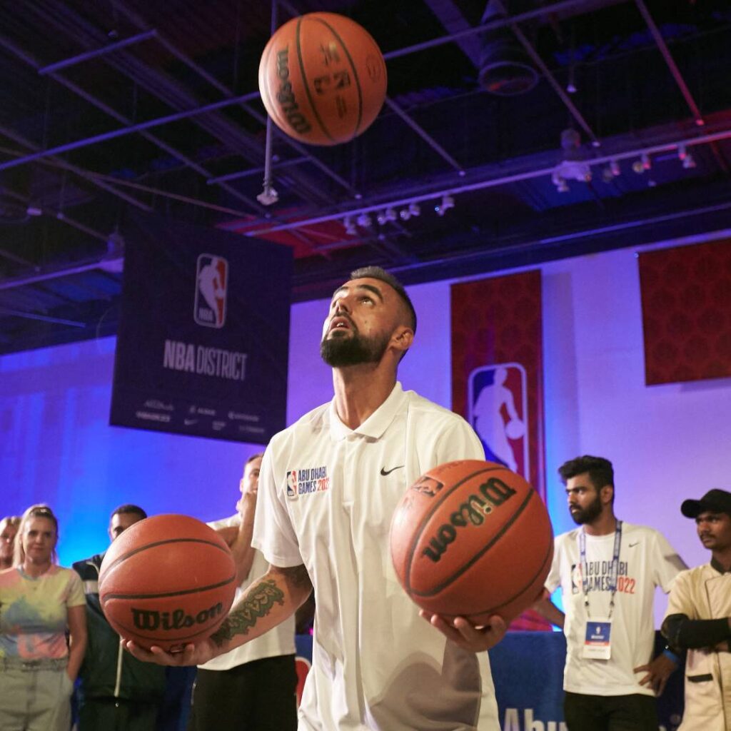 Incredible basketball freestyler juggling three balls during an exhibition show.