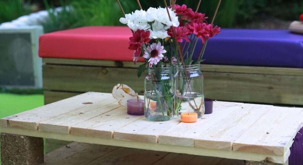 Pretty flower and jar table centrepieces used for festival theme ideas at a music themed festival.