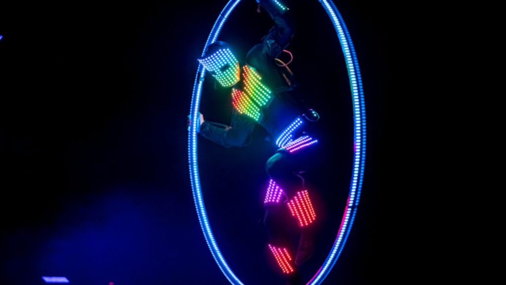 LED wheel dancer wearing glowing suit.