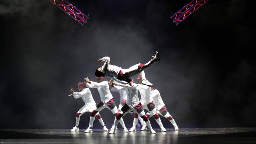 Famous dance troupe Flawless performing on stage in white outfits for corporate event.